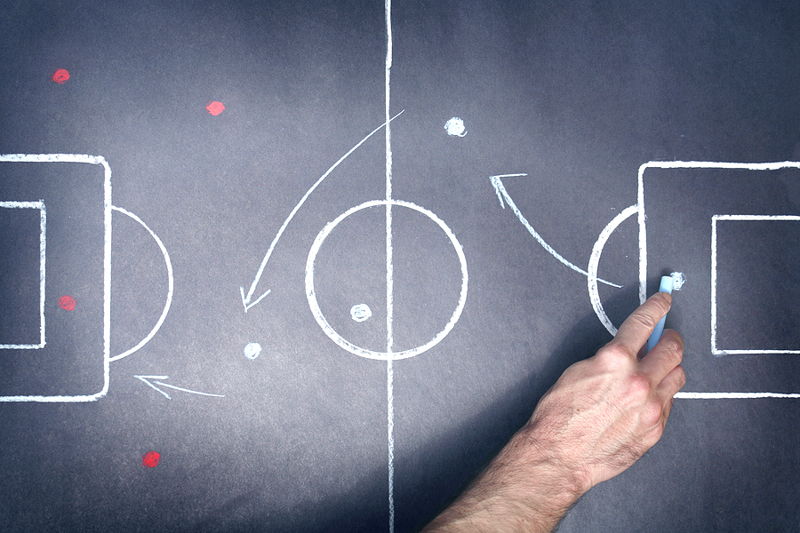 football tactics board with hand and chalk on goalkeeper position