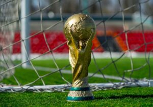 world cup trophy on grass next next to goal net close up